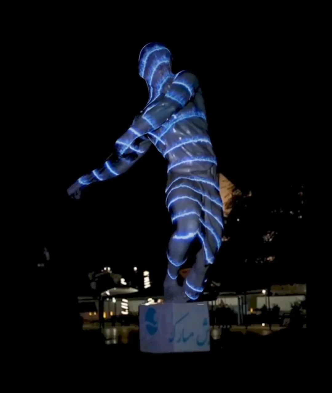 Human statue covered in blue glowing light patterns for Kish Island video mapping